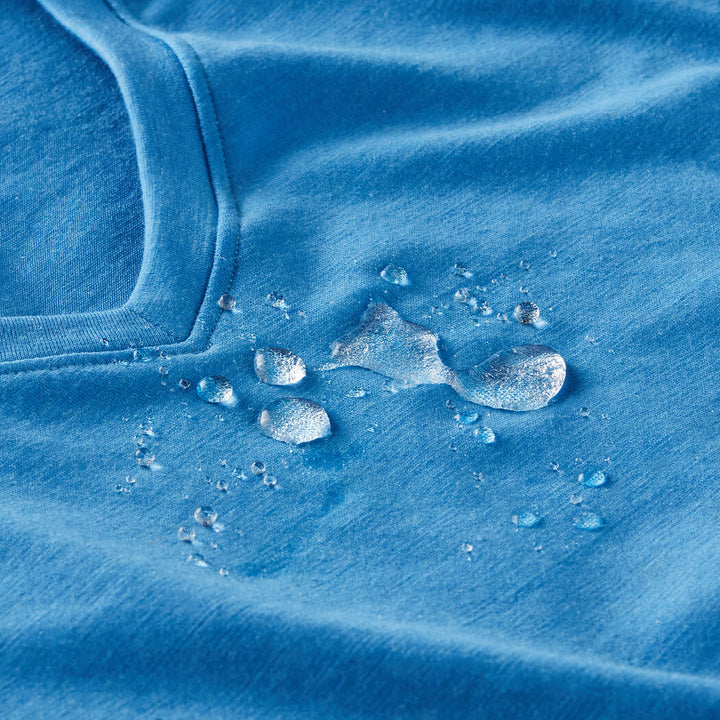 Blue t shirt showing water droplets beaded on merino wool and not absorbed